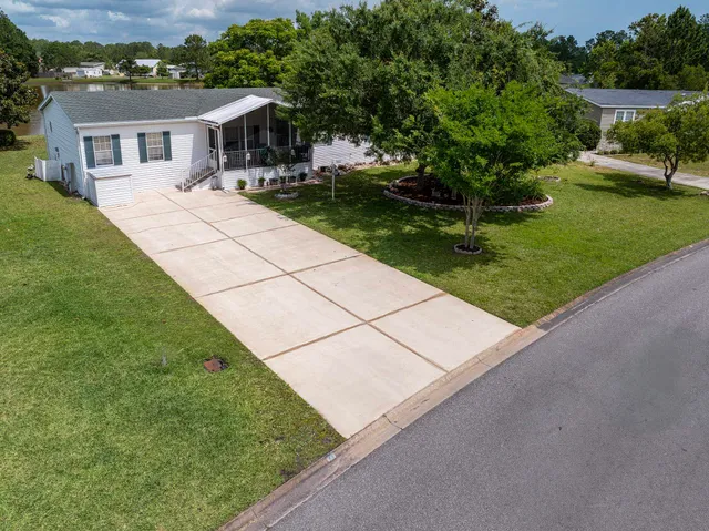 an aerial view of a house with a garden and lake view