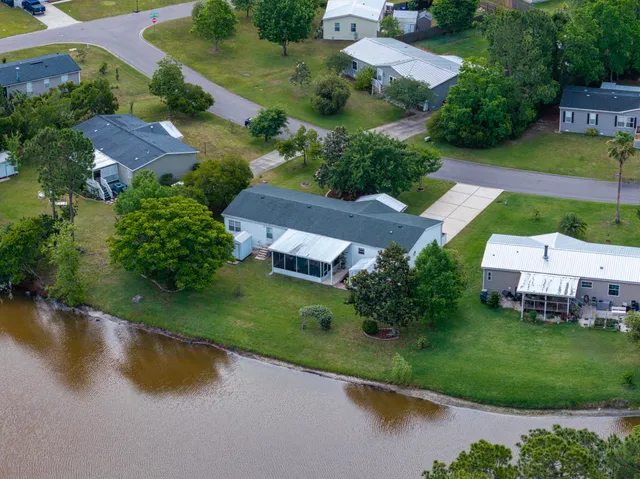 an aerial view of a house with a garden and lake view
