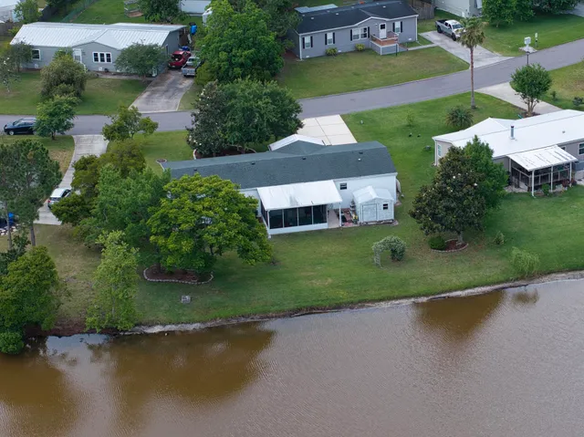 an aerial view of a house with a swimming pool yard and lake view