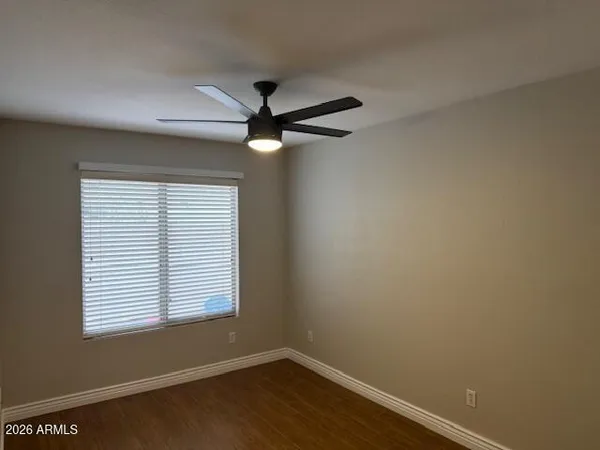 an empty room with a window and a fan