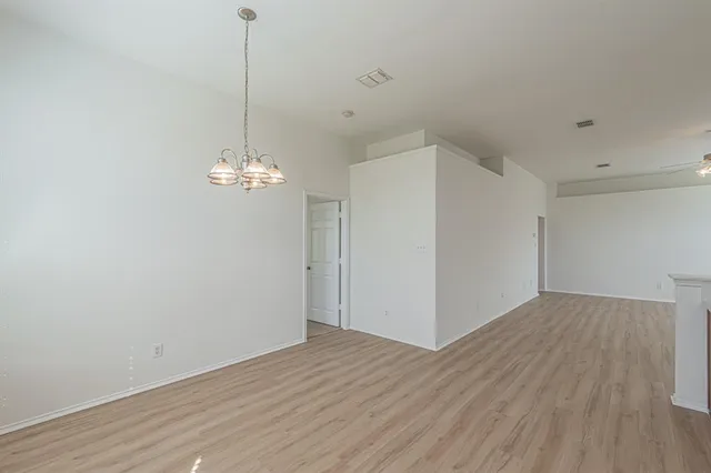 a view of a room with wooden floor and chandelier