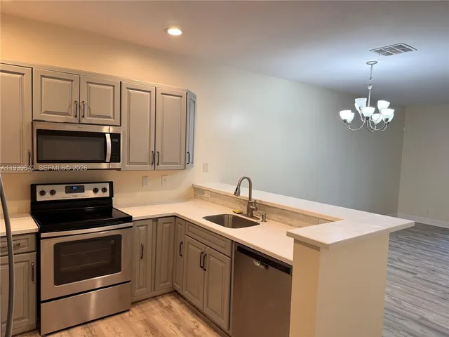 a kitchen that has a sink and a stove top oven