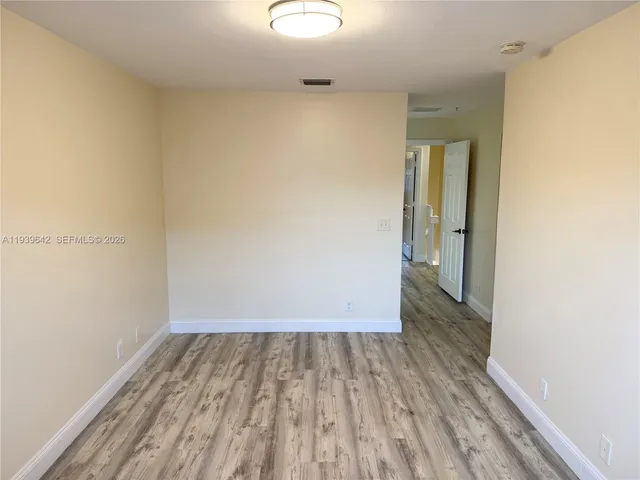 a view of a room with wooden floor
