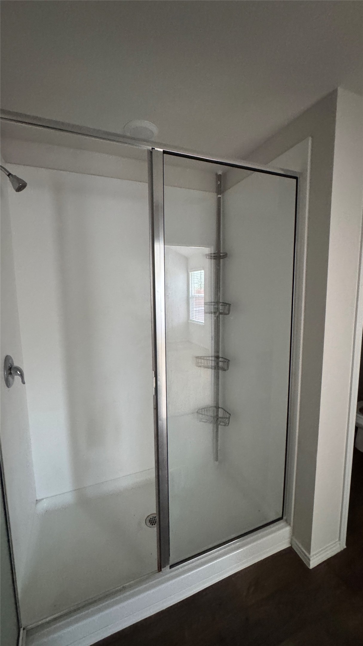 408 Frogmore Loop Kyle, TX 78640 - Photo 14 of 32 Modern shower with sliding glass doors and dark hardwood flooring.