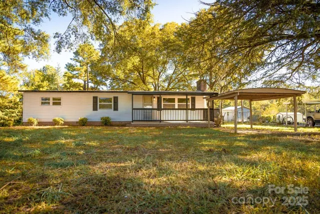 a view of a house with a big yard and potted plants