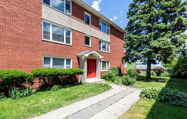 a front view of a house with yard and green space