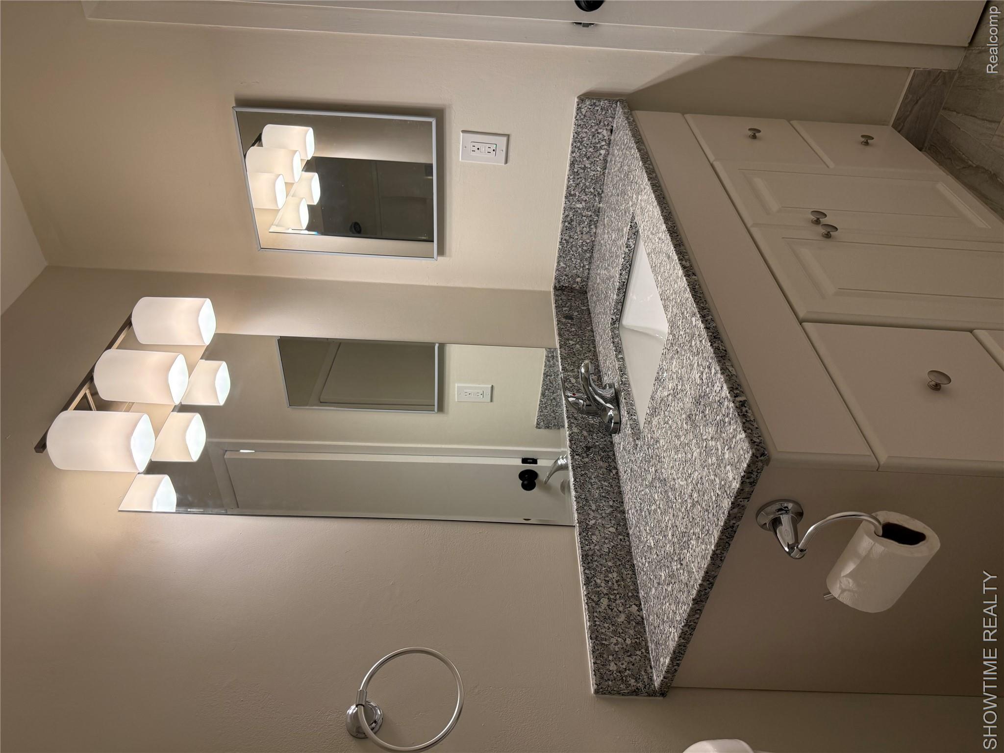 29141 Hayes Road Warren, MI 48088 - Photo 14 of 18 White vanity with a granite countertop, integrated sink, and chrome faucet