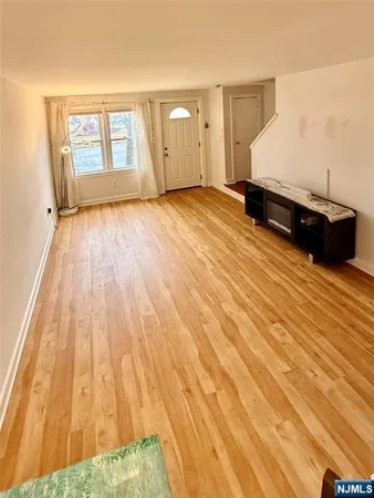 a view of a bedroom with wooden floor and window