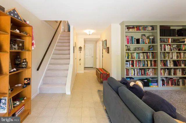 a living room with furniture and a book shelf