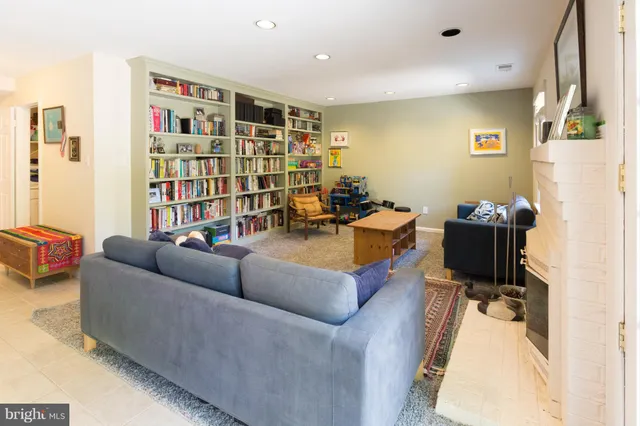 a living room with furniture and a book shelf
