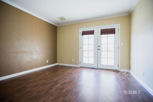 1233 South Ranger Street Ridgecrest, CA 93555 - Photo 17 of 30 a view of an empty room with wooden floor and a window