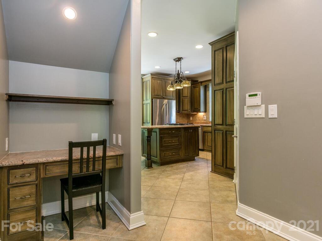 356 Green Hills Road Mill Spring, NC 28756 - Photo 11 of 31 a kitchen with stainless steel appliances kitchen island granite countertop a refrigerator and a stove top oven