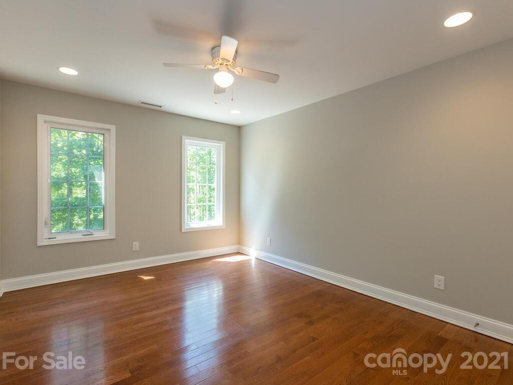 356 Green Hills Road Mill Spring, NC 28756 - Photo 20 of 31 an empty room with wooden floor and windows