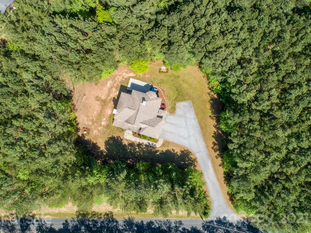 356 Green Hills Road Mill Spring, NC 28756 - Photo 29 of 31 an aerial view of a house with a yard lake and trees all around