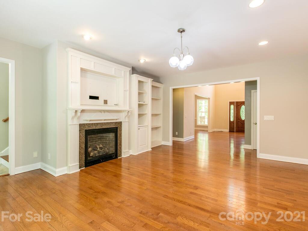 356 Green Hills Road Mill Spring, NC 28756 - Photo 6 of 31 a view of an empty room with wooden floor fireplace and a window