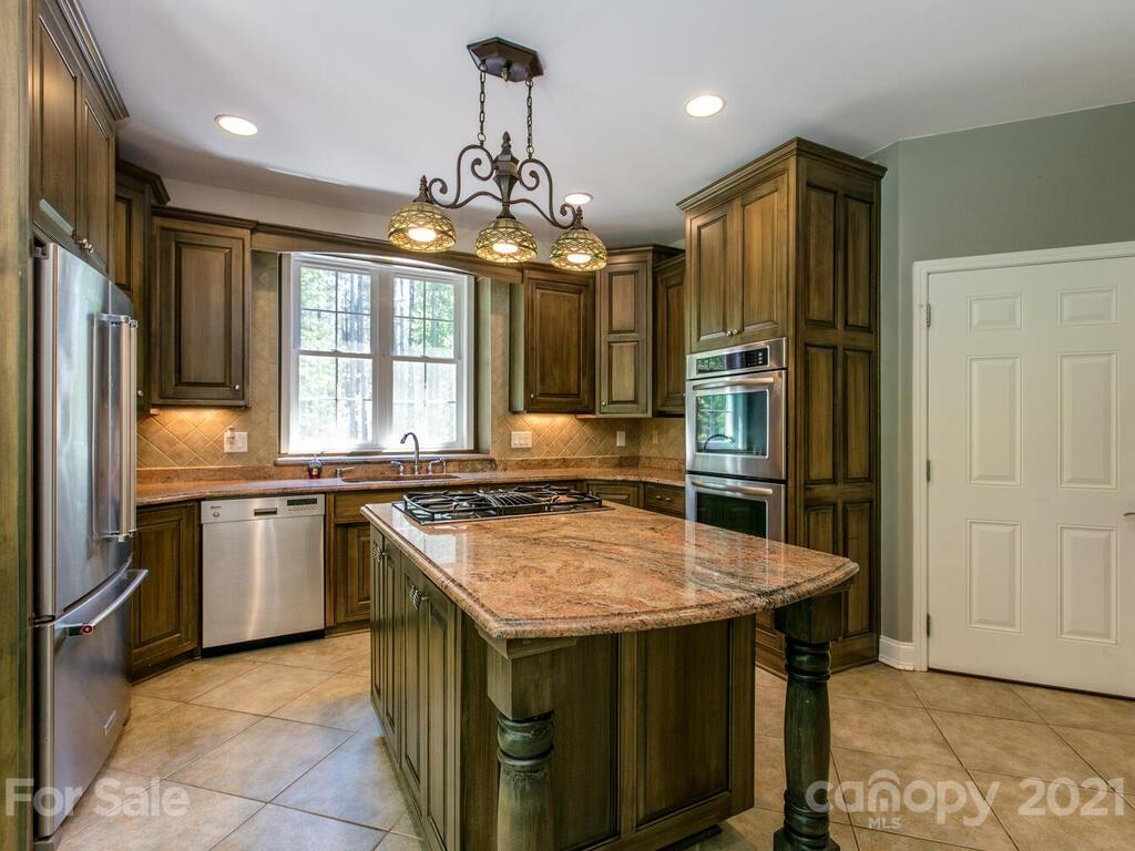 356 Green Hills Road Mill Spring, NC 28756 - Photo 8 of 31 a kitchen with stainless steel appliances granite countertop a sink stove and refrigerator
