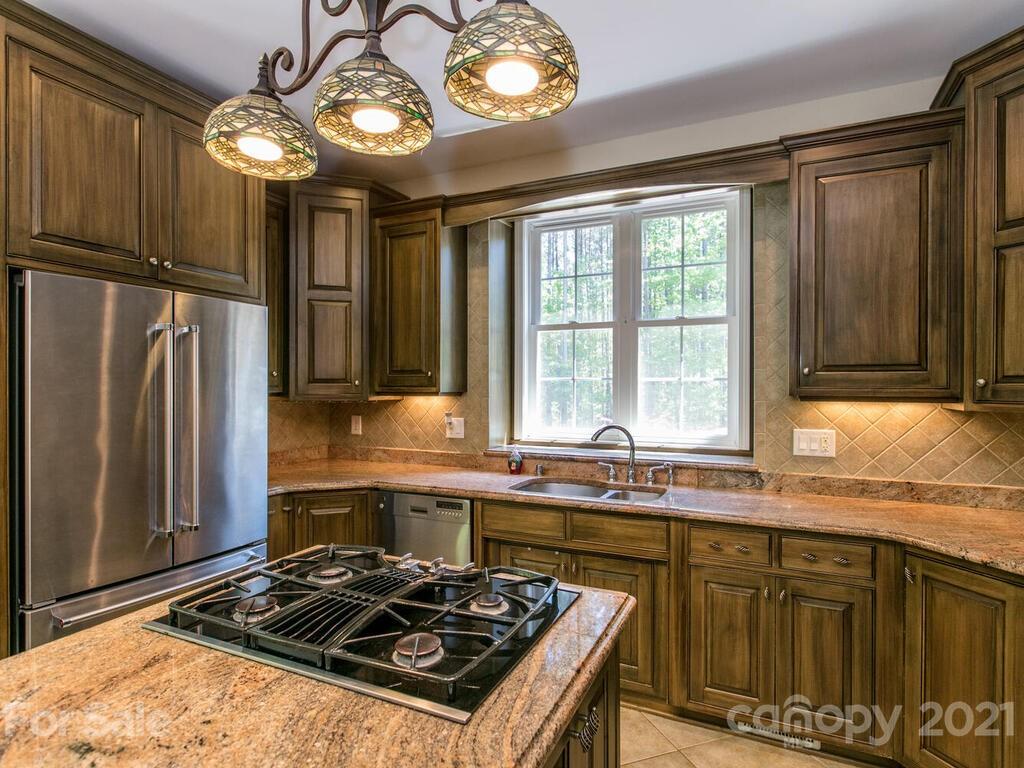 356 Green Hills Road Mill Spring, NC 28756 - Photo 9 of 31 a kitchen with stainless steel appliances granite countertop a stove a refrigerator and a sink