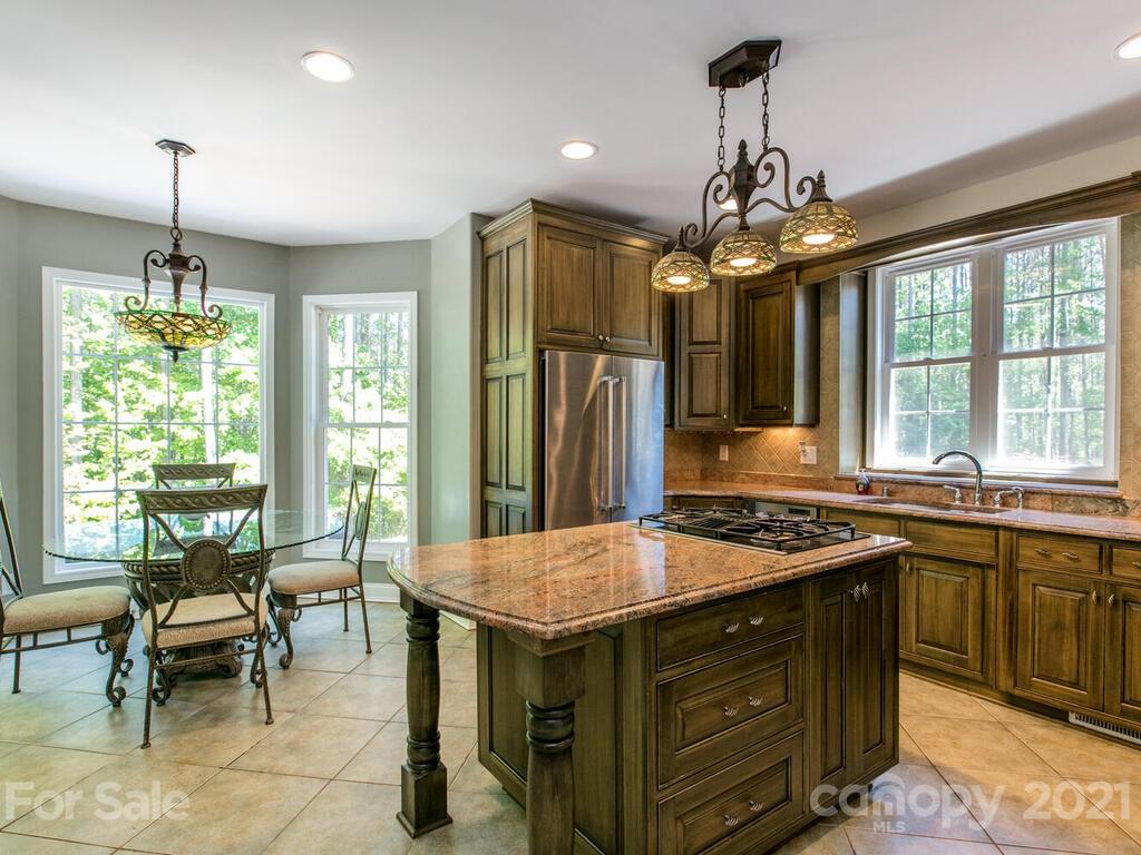 356 Green Hills Road Mill Spring, NC 28756 - Photo 10 of 31 a kitchen that has a stove a table and chairs in it