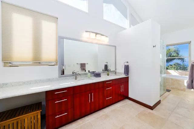 a bathroom with a granite countertop double vanity sink and a mirror