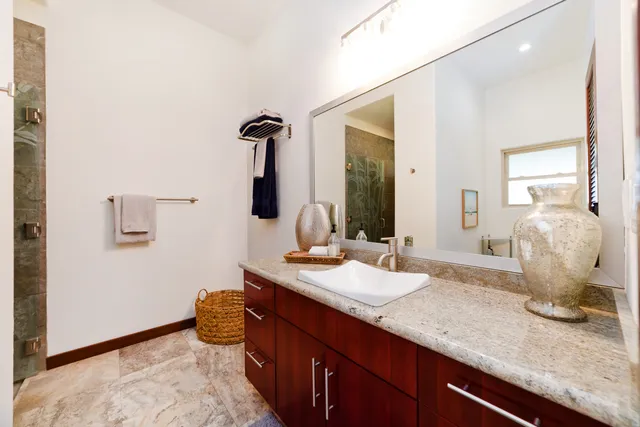 a bathroom with a granite countertop sink and a mirror