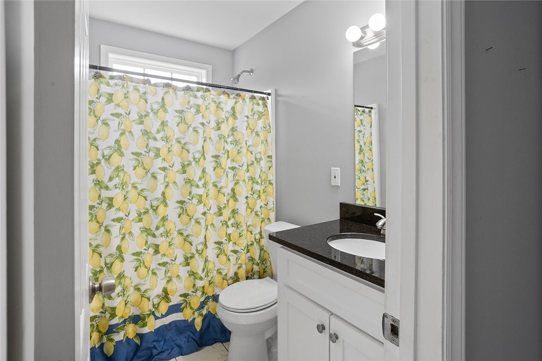 119 Nicholas Court Easley, SC 29640 - Photo 9 of 33 This bright bathroom features a vanity with a dark countertop and a shower with a patterned curtain.