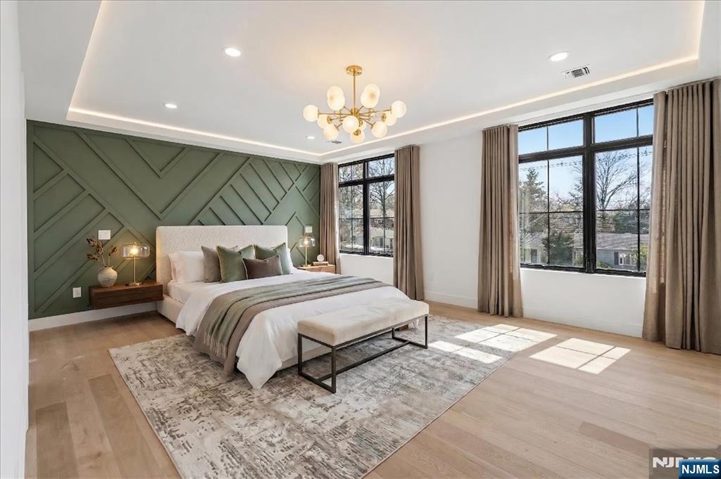150 Howland Avenue River Edge, NJ 07661 - Photo 44 of 45 a spacious bedroom with a large bed and a chandelier