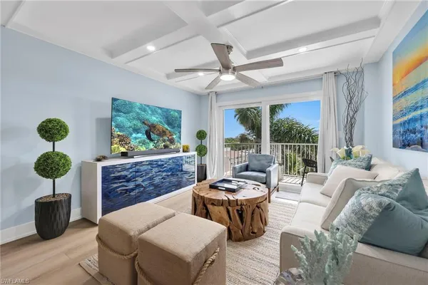 a living room with furniture a chandelier and a potted plant