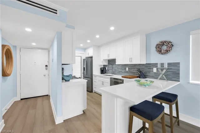 a kitchen with a sink a microwave a refrigerator and cabinets