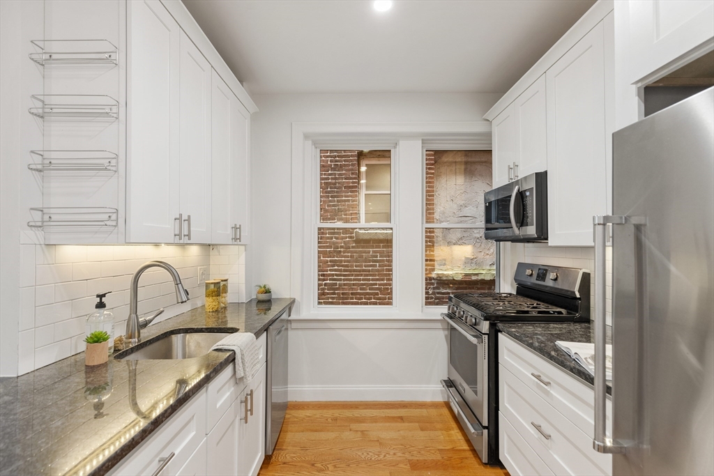 81 Prince Street, Unit 2 Boston, MA 02113 - Photo 9 of 22 a kitchen with stainless steel appliances granite countertop a sink stove and refrigerator