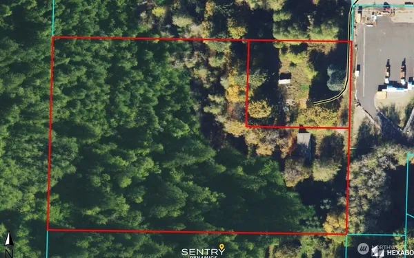an aerial view of residential houses with outdoor space and trees