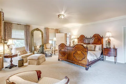 a spacious bedroom with bed and a large mirror