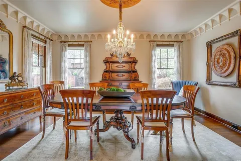 a dining room with furniture a chandelier and wooden floor