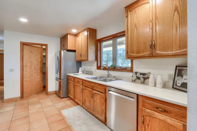 a kitchen with a sink refrigerator and cabinets