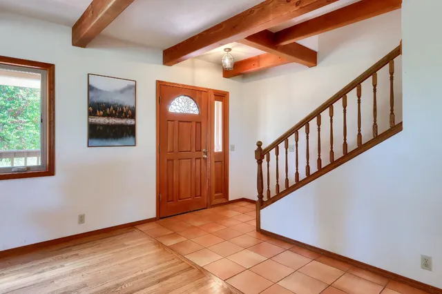 a view of a hallway with wooden floor and staircase