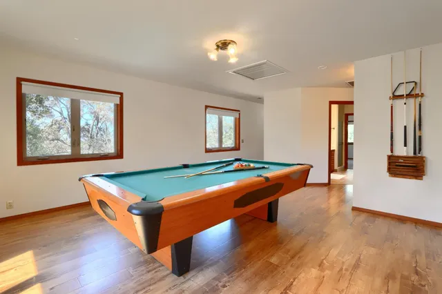 a room with pool table and windows
