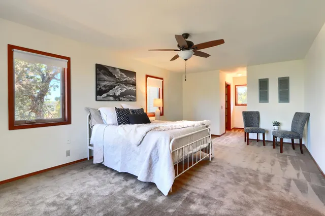 a spacious bedroom with a bed a couch and a window