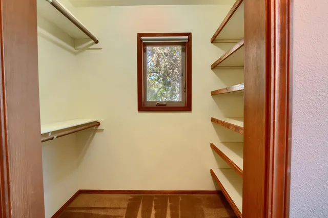 a view of a hallway with wooden floor and a window
