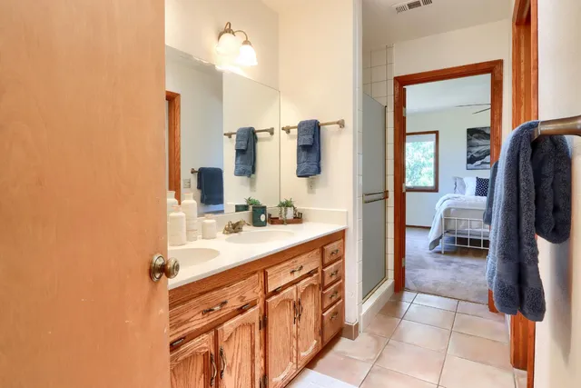 a en suite bathroom with a double vanity sink and a mirror