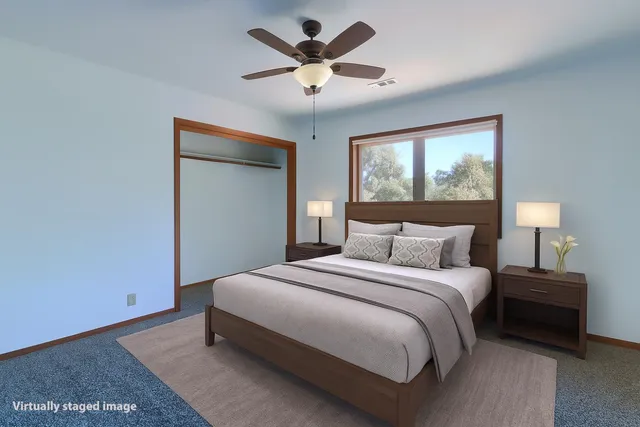 a view of an empty room with window and a ceiling fan