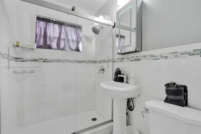 a kitchen with stainless steel appliances granite countertop a stove refrigerator a dining table and chairs with wooden floor