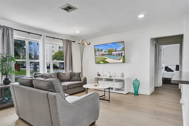 a living room with furniture and a air conditioner vent