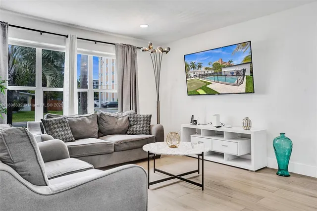 a living room with furniture a flat screen tv and a fireplace