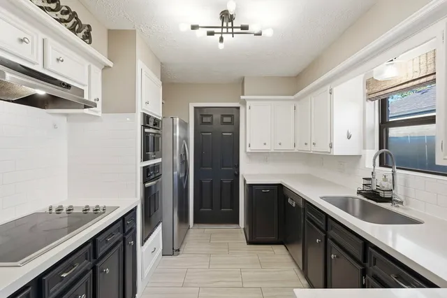 a kitchen with stainless steel appliances granite countertop a refrigerator and a sink