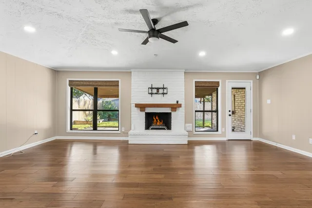 a view of an empty room with window and wooden floor