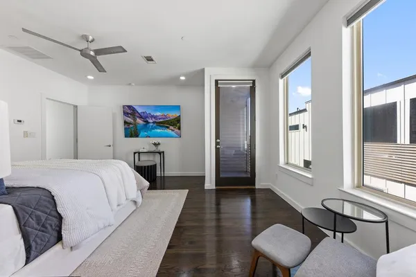 a spacious bedroom with a bed and wooden floor
