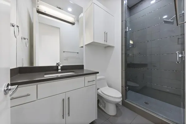 a bathroom with a sink a toilet and shower