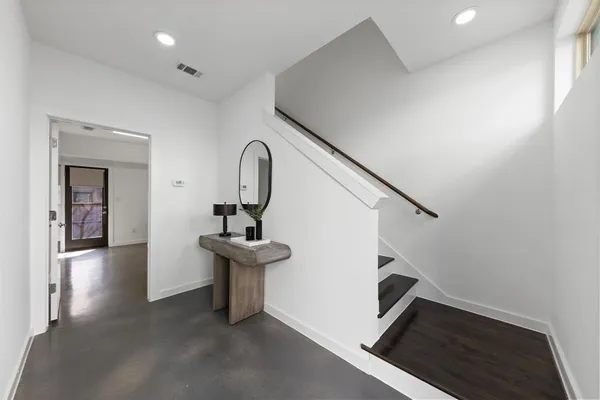 a view of entryway and hall with wooden floor