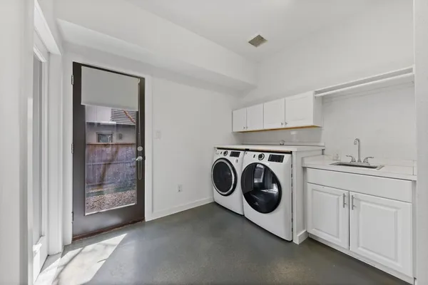 a utility room with sink dryer and washer