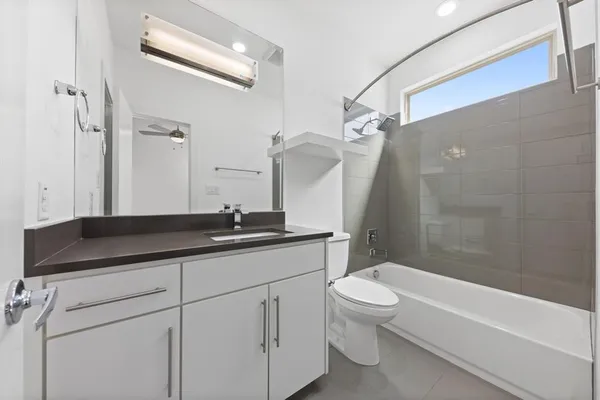 a bathroom with a granite countertop sink a toilet and a bathtub