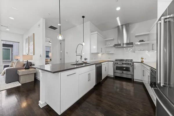 a kitchen with stainless steel appliances a sink a stove and a wooden floors